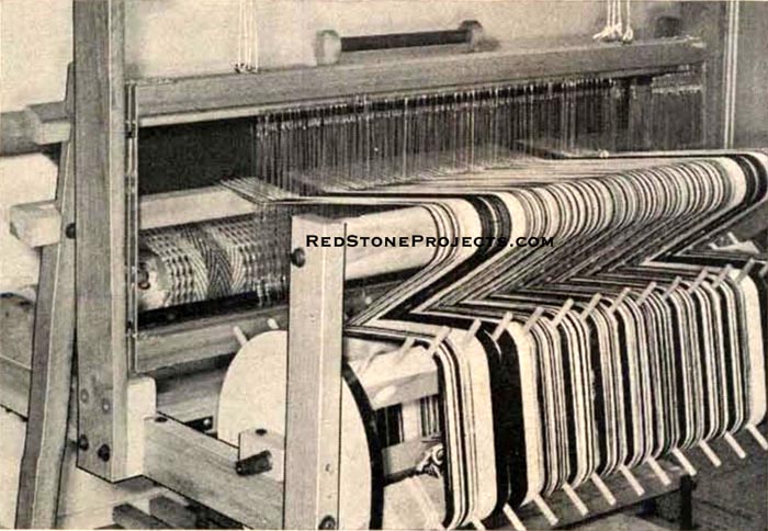 Figure 3. Rear view of loom shows enough thread on warp beam to weave ten 54 in. long rugs. Warp beam rotates.