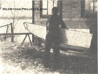 Carrying the folded boat down to the lake. Notice the folded bottom projecting above the side piece.