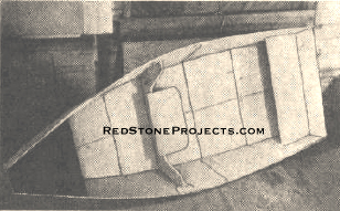 The completed boat with canvas “deck” stretched across the bow. Removable center section with seat, plywood transom, and transom seat hold the boat rigid when it is opened up. The parts named can be taken out and installed quickly.