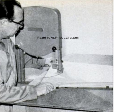 The side members of the frame are brought to their finished form with a bandsaw. Large work is easier to handle if you rig up an auxiliary table as shown.